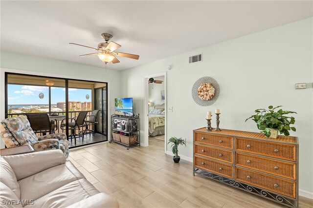 living room with ceiling fan and light wood-type flooring