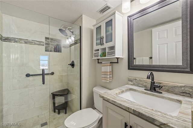 bathroom with vanity, a shower with door, and toilet