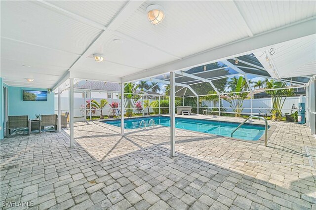 view of pool with a patio and glass enclosure