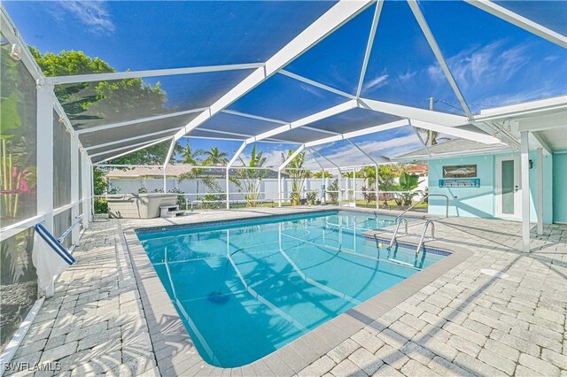 view of swimming pool with a hot tub, a patio, and glass enclosure