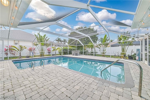 view of pool with glass enclosure, a fenced backyard, a patio area, and a fenced in pool