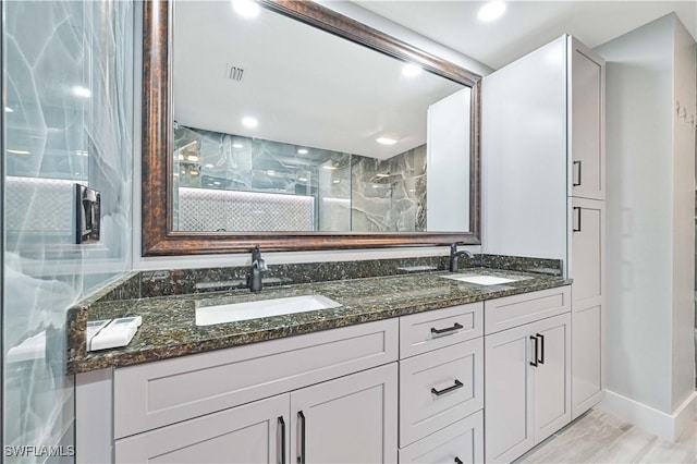 bathroom with vanity and a shower with door