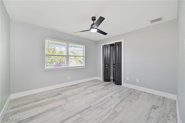 unfurnished bedroom with ceiling fan and a closet