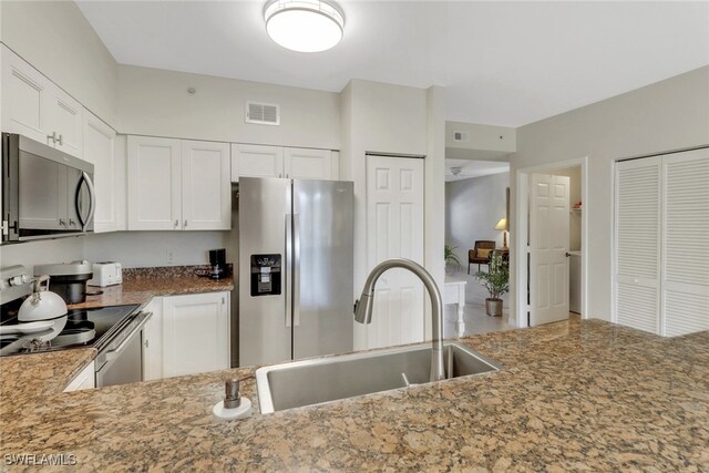 kitchen with white cabinetry, sink, stainless steel appliances, and stone countertops