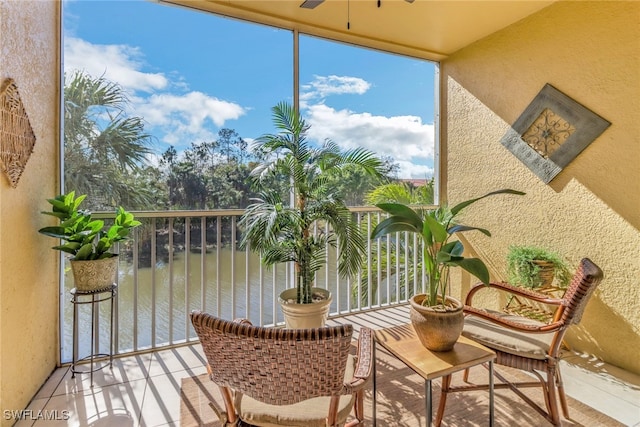 sunroom with a water view and ceiling fan