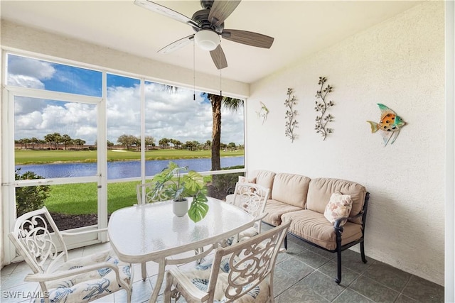 sunroom with a water view and a ceiling fan