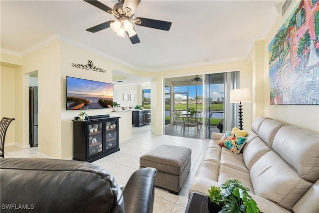 living area with light tile patterned floors, baseboards, ornamental molding, and a ceiling fan