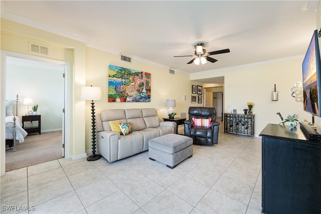 living area featuring a ceiling fan, visible vents, crown molding, and light tile patterned flooring