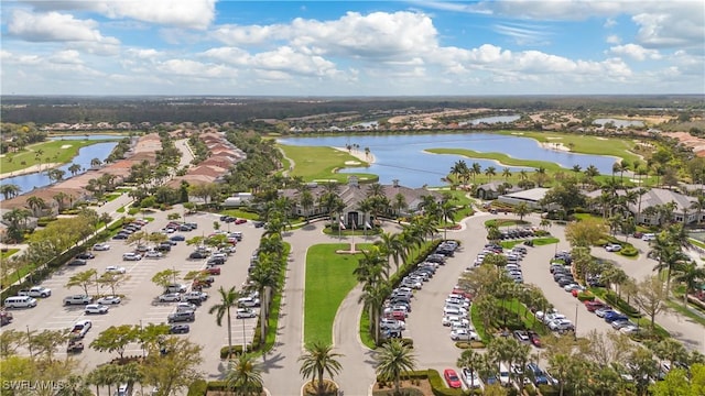 drone / aerial view with view of golf course and a water view