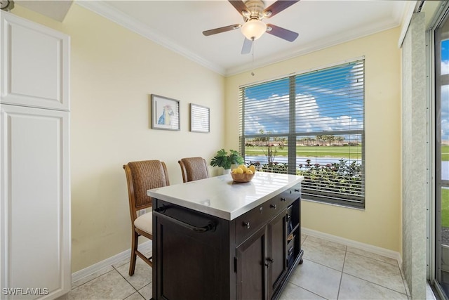 dining area featuring baseboards, crown molding, and light tile patterned flooring