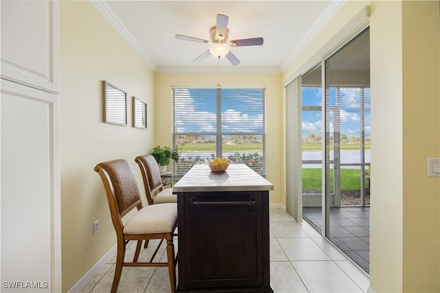 dining area featuring light tile patterned floors, baseboards, ornamental molding, and a ceiling fan