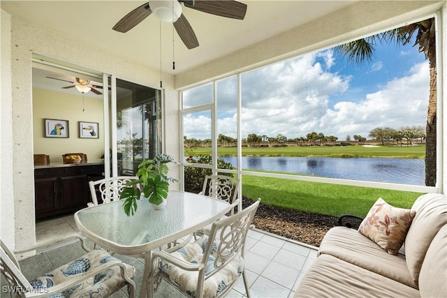 sunroom / solarium with a water view and a ceiling fan