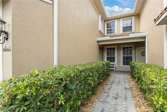 doorway to property featuring stucco siding