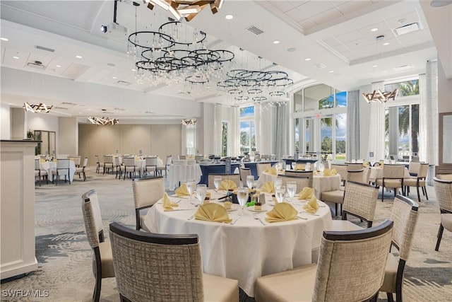 carpeted dining room featuring recessed lighting, a high ceiling, visible vents, a tray ceiling, and an inviting chandelier