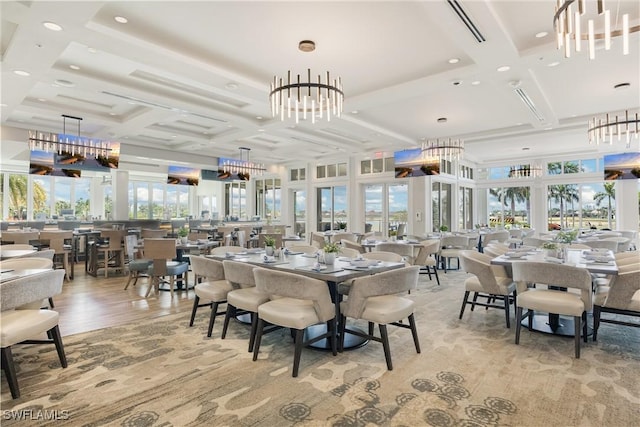 dining space with light wood-style floors, a wealth of natural light, coffered ceiling, and a towering ceiling