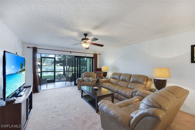 living room featuring ceiling fan, light colored carpet, and a textured ceiling