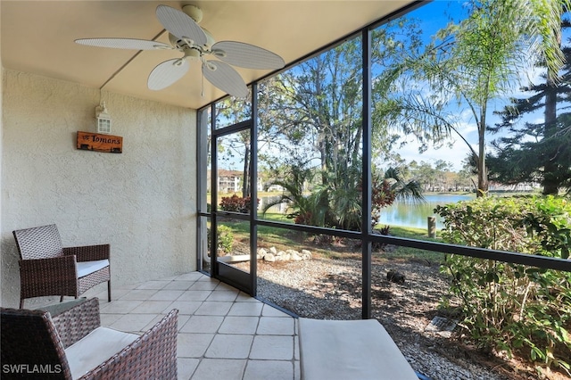 sunroom featuring a water view and ceiling fan