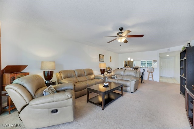 living room featuring ceiling fan, light colored carpet, and a textured ceiling