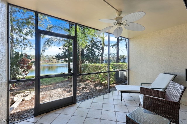 sunroom featuring a water view and ceiling fan