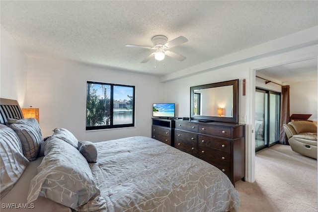 bedroom featuring ceiling fan, light colored carpet, and a textured ceiling