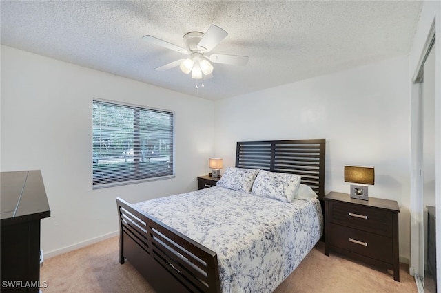 carpeted bedroom with ceiling fan and a textured ceiling