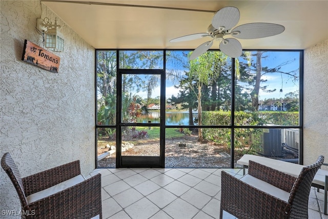 sunroom featuring a water view, a healthy amount of sunlight, and ceiling fan