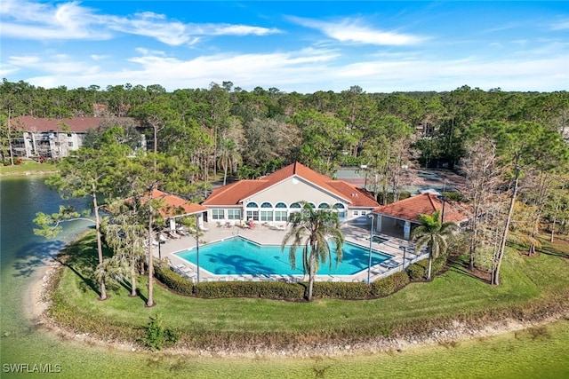 view of swimming pool with a water view and a lawn