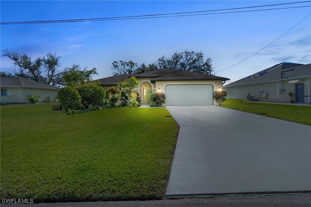 view of front of property with a garage, concrete driveway, a front lawn, and stucco siding