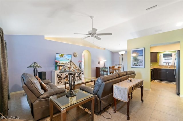 living room with ceiling fan, lofted ceiling, and light tile patterned floors