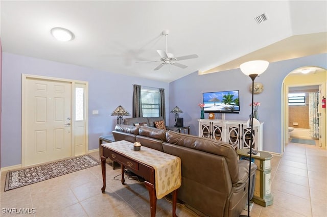 living room with lofted ceiling, light tile patterned floors, and ceiling fan