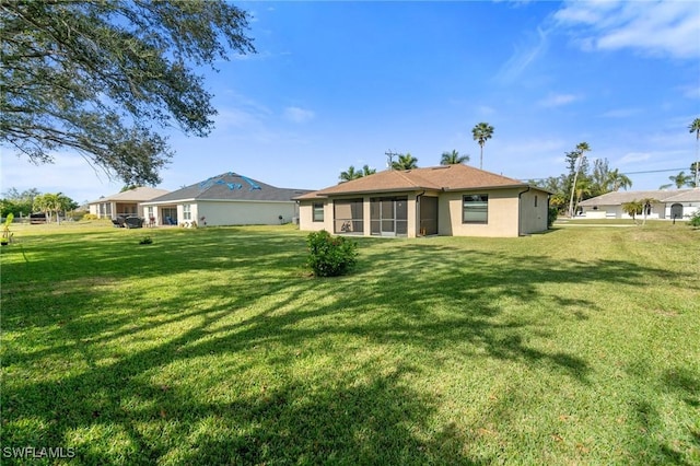 rear view of property featuring a lawn