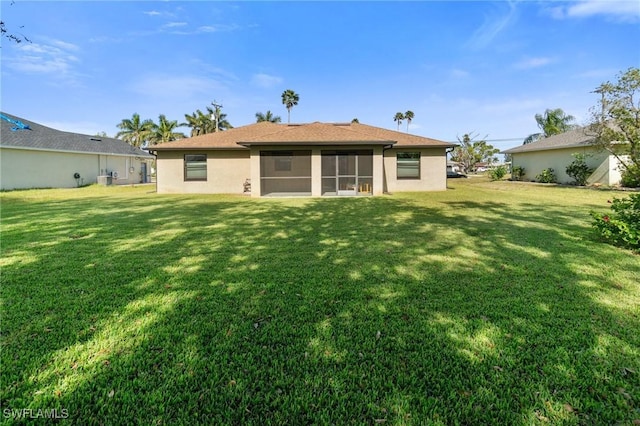 back of property with a lawn and a sunroom