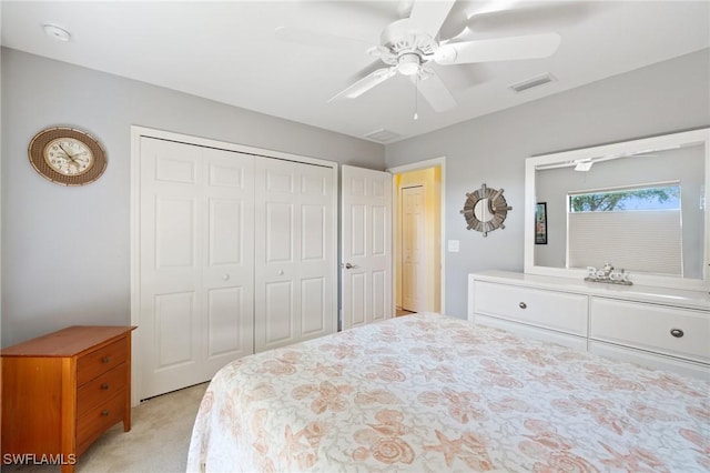 bedroom with ceiling fan, a closet, visible vents, and light colored carpet