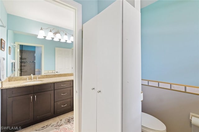 bathroom featuring vanity, tile patterned floors, and toilet