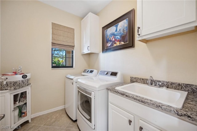 washroom with sink, cabinets, washer and dryer, and light tile patterned flooring