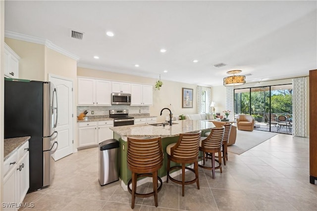 kitchen featuring sink, white cabinets, a kitchen island with sink, light stone counters, and stainless steel appliances