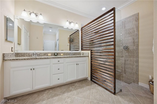 bathroom with ornamental molding, tile patterned flooring, vanity, and a tile shower