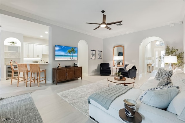 living room featuring crown molding and ceiling fan