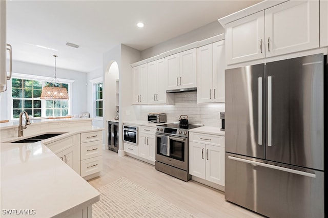 kitchen with appliances with stainless steel finishes, sink, and white cabinets