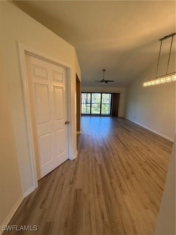 unfurnished living room with lofted ceiling, hardwood / wood-style floors, and ceiling fan