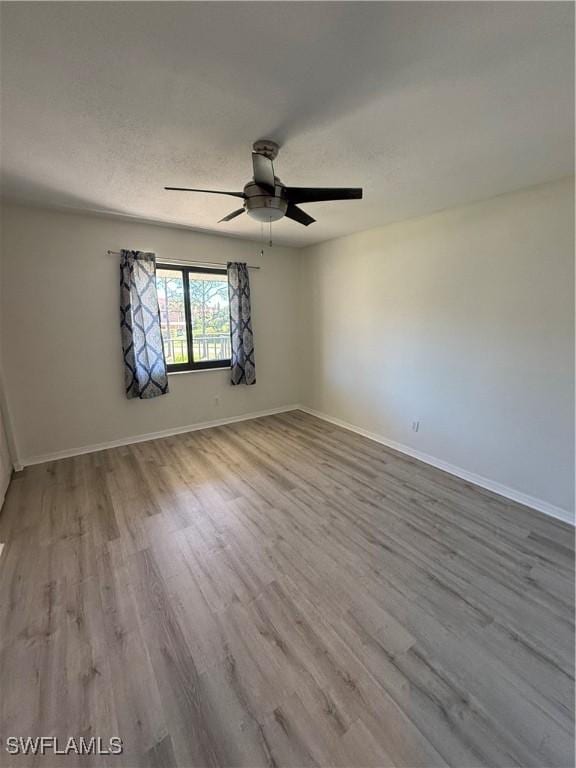 empty room with a textured ceiling, ceiling fan, and light wood-type flooring