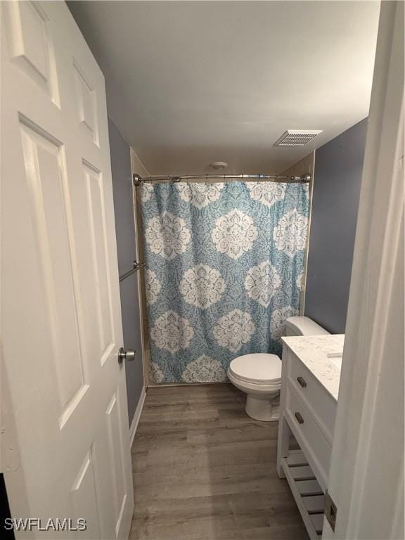 bathroom with vanity, hardwood / wood-style flooring, and toilet