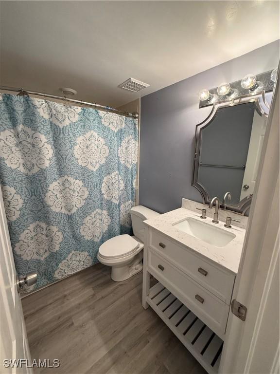 bathroom with vanity, hardwood / wood-style flooring, and toilet