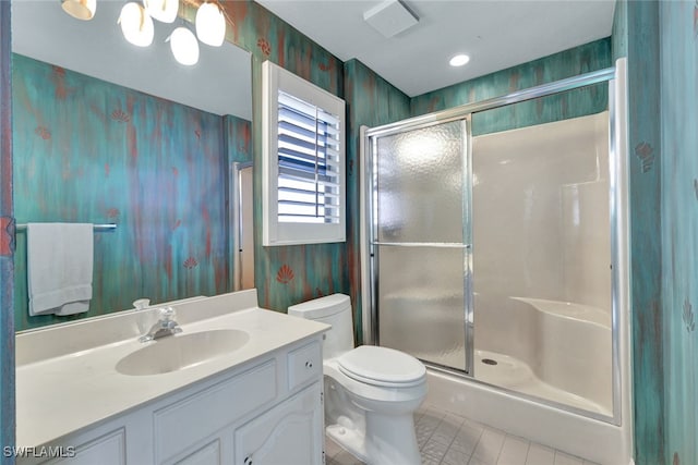 bathroom featuring tile patterned flooring, toilet, vanity, and a shower with shower door