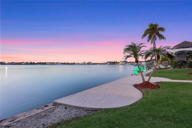 dock area featuring a water view and a lawn