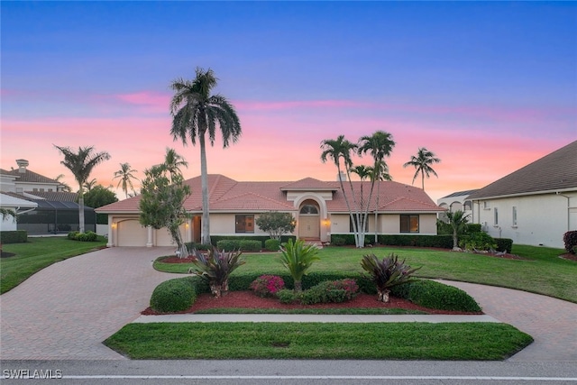 ranch-style home with a garage and a lawn