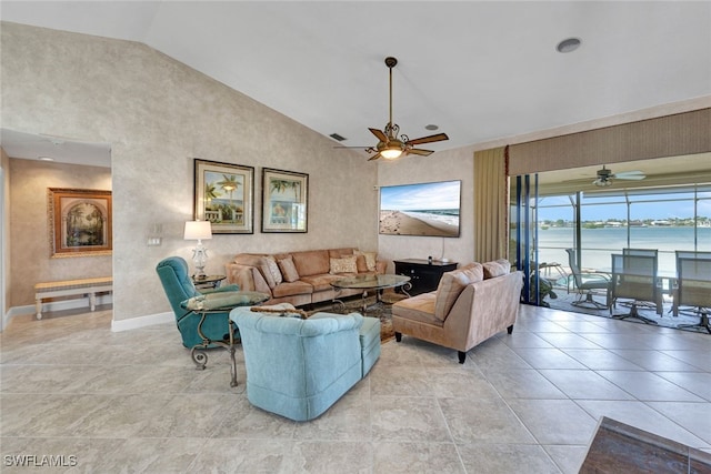 tiled living room with ceiling fan and high vaulted ceiling