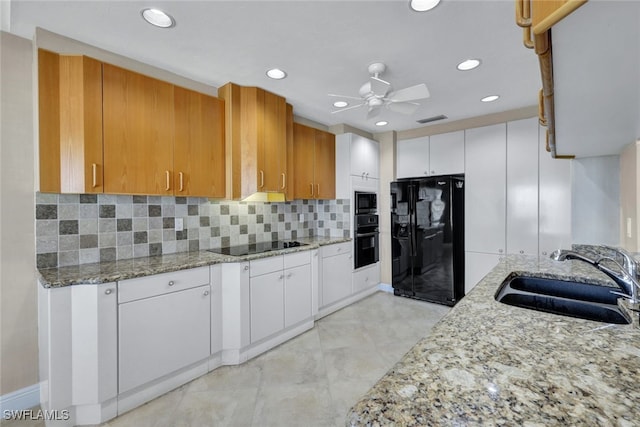 kitchen featuring white cabinetry, light stone countertops, sink, and black appliances