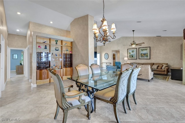 dining space with ceiling fan with notable chandelier and high vaulted ceiling