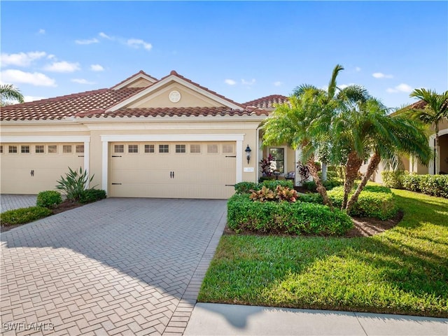 mediterranean / spanish-style house with a garage and a front lawn